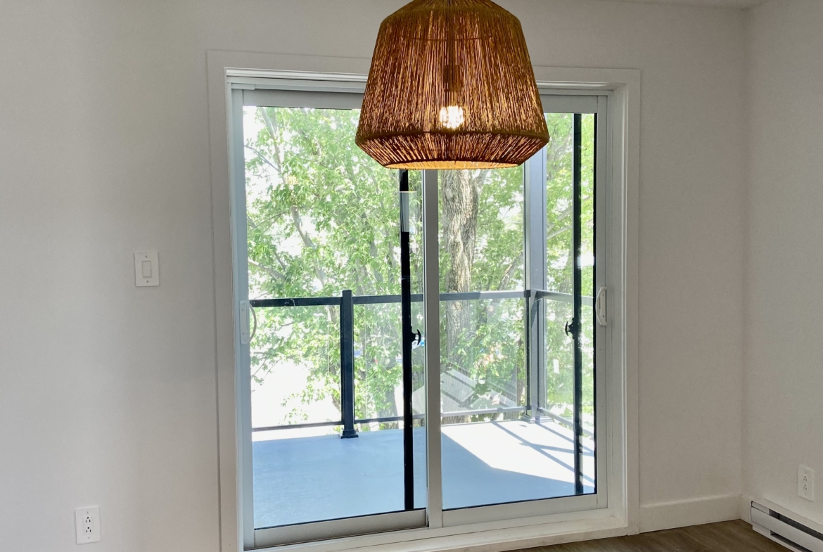 Salle à manger avec porte patio menant au balcon