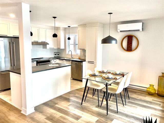 Salle à manger avec vue sur la cuisine. Luminosité abondante